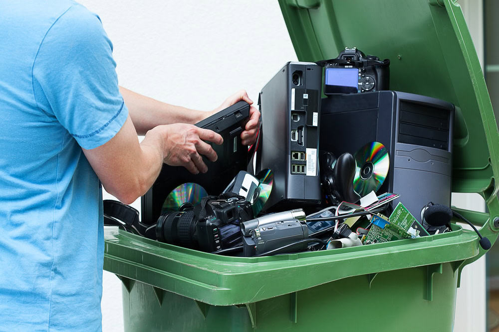 Man,discarding,old,electronics,int,the,plastic,bin
